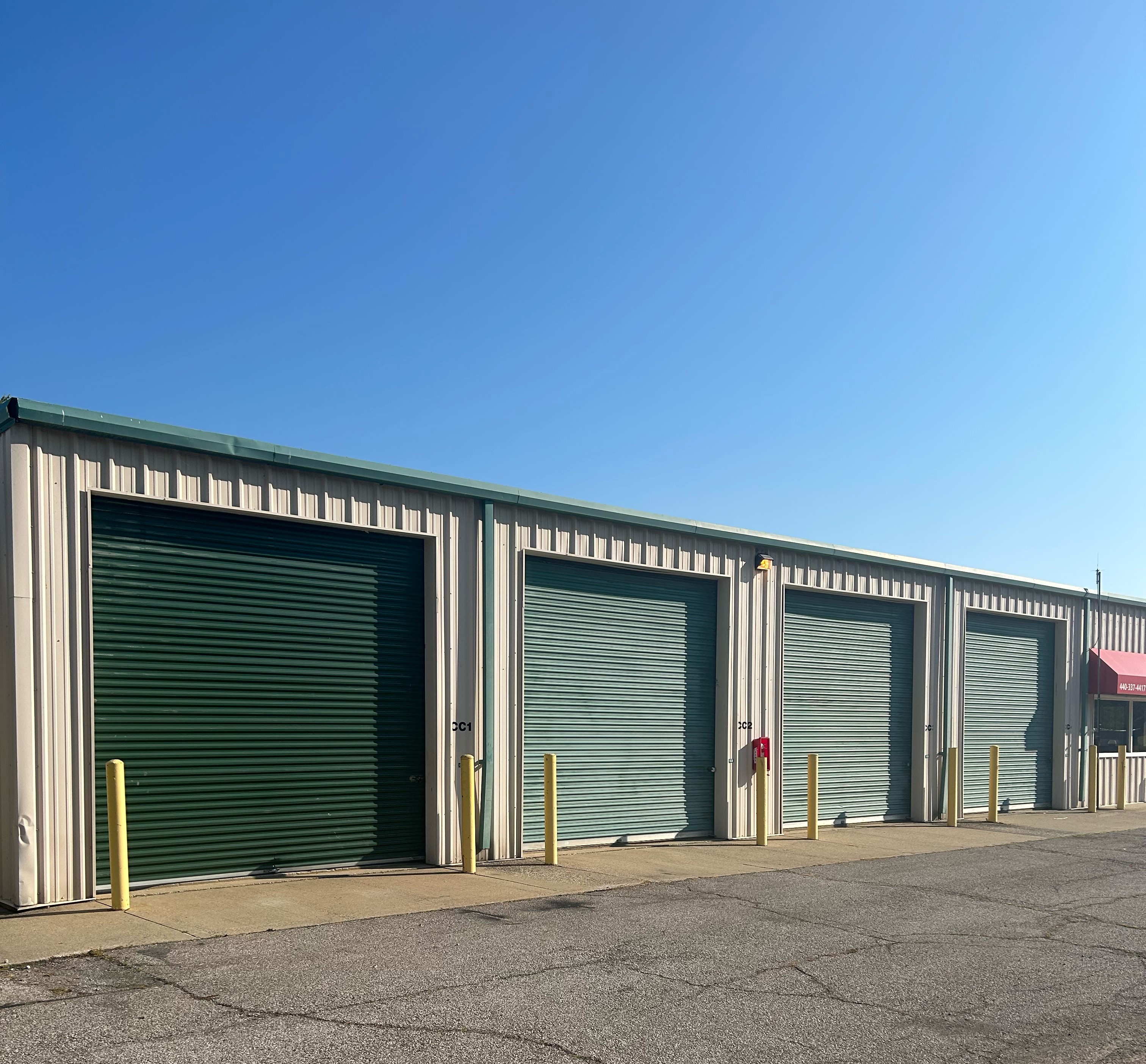 Green exterior storage units with yellow bollards